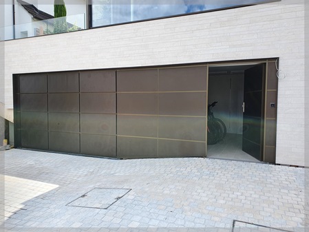 Garagentor, Türe und Festfeld bündig in Aluminiumfassade integriert