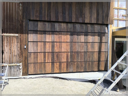 Detailansicht der wiederverwendeten Holzverkleidung des Garagentors