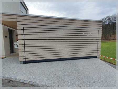Garagentor mit 19 mm Holzbeplankung im Carport eines Einfamilienhauses