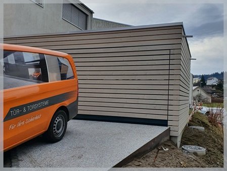 Geöffnetes Garagentor mit Echtholz-Beplankung im Carport