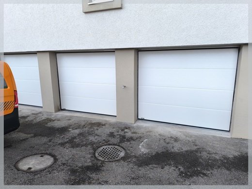 Drei ansichtsgleiche Garagentore an einem Mehrfamilienhaus